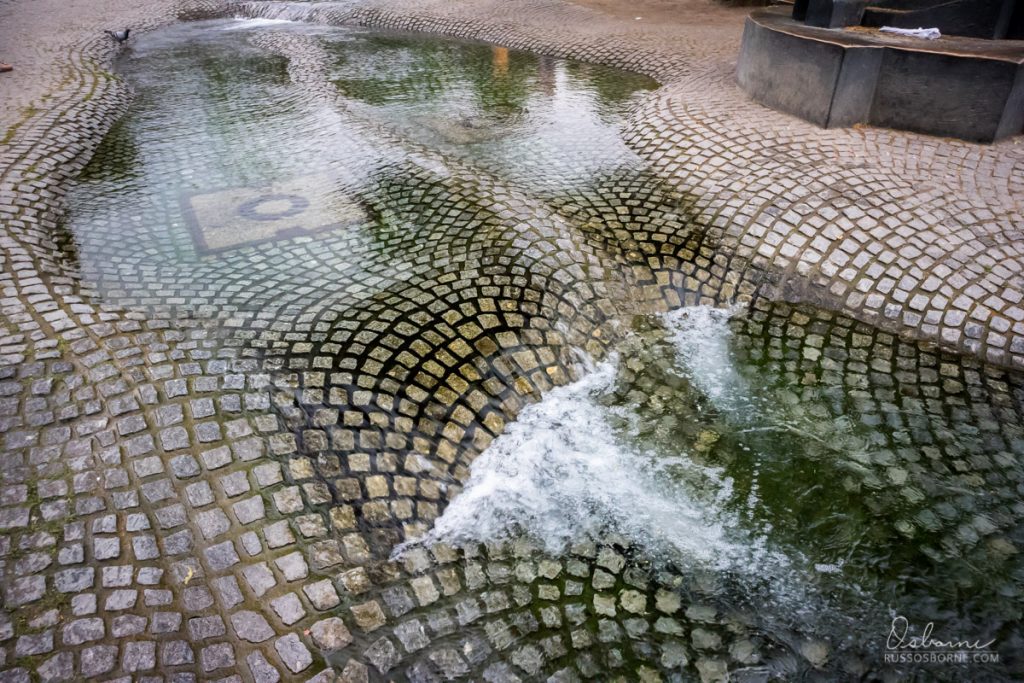 manmade water feature over cobblestone