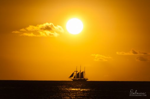 Three masted schooner silhouette in the setting sun..
